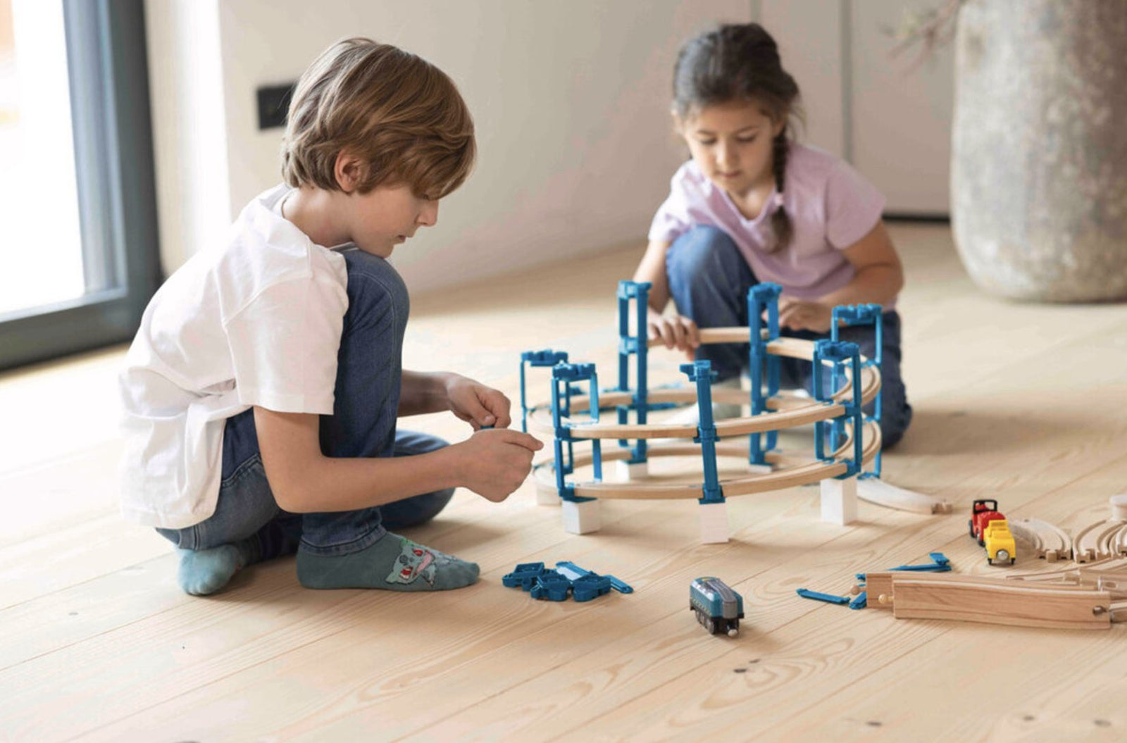 Kinderen bouwen een houten treinbaan met Yamba in meerdere niveaus