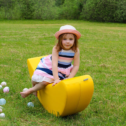 A girl sitting on a yellow banana shaped rocker