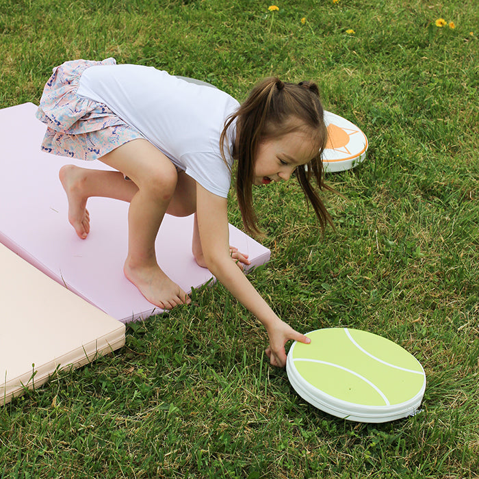 A girl playing on her pink foam mattress 