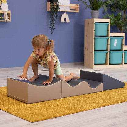 A little girl playing with an IGLU Soft Play - Wave Venture in a room.