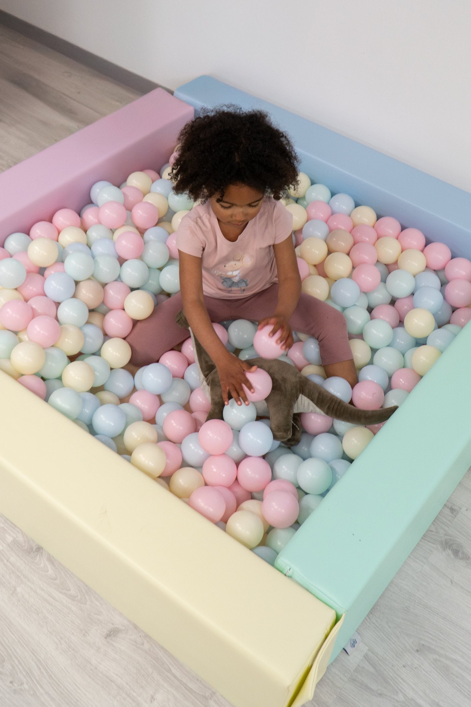 Kind speelt in de IGLU Square Ball Pit in pastelkleuren met zachte foamwanden