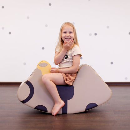 A girl sitting on a IGLU rocker, blowing a kiss