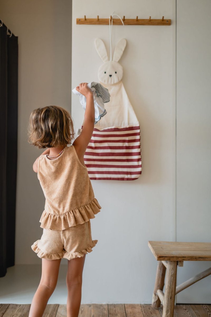 Toto Bunny mit Büchern und Kuscheltieren neben dem Bett