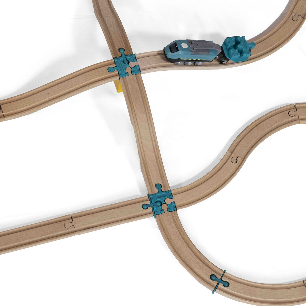 Trein op houten rails met blauwe Yamba Cross-Bar-onderdelen bij twee kruisingen